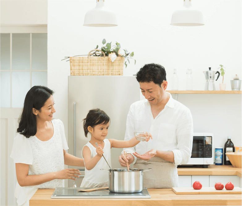 写真：キッチンで一緒に調理をする家族
